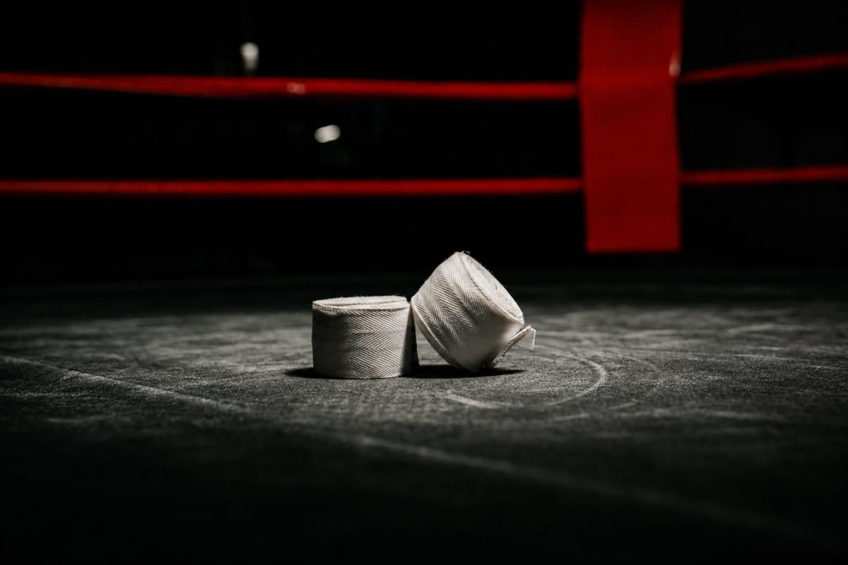 Pair of short white tape wraps lying on a dark round canvas under a spotlight (AI-generated image)